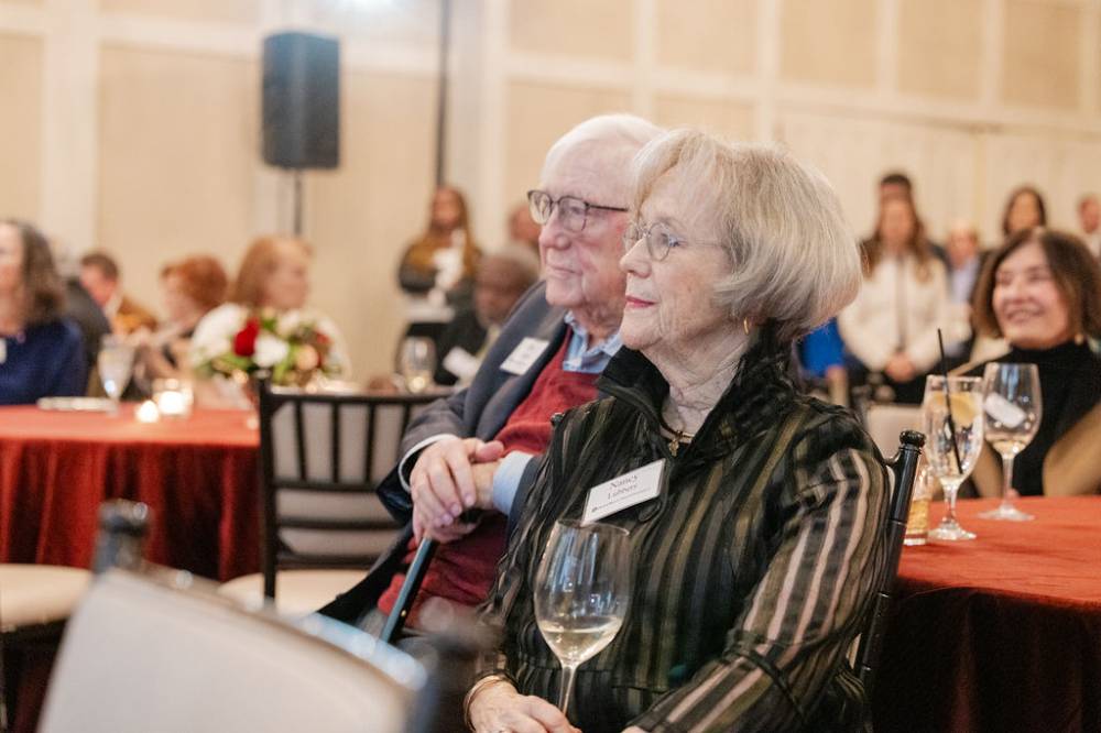 Don and Nancy Lubbers sitting together and looking up at stage